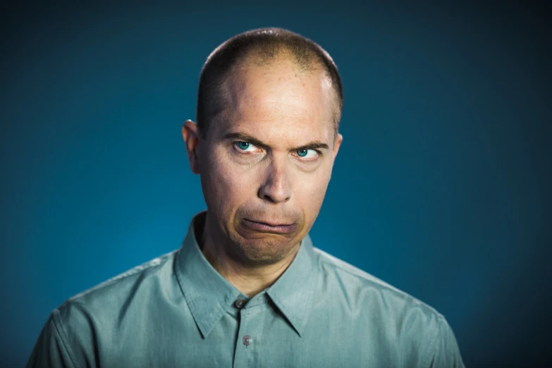 a man is posing for the camera while wearing a green shirt