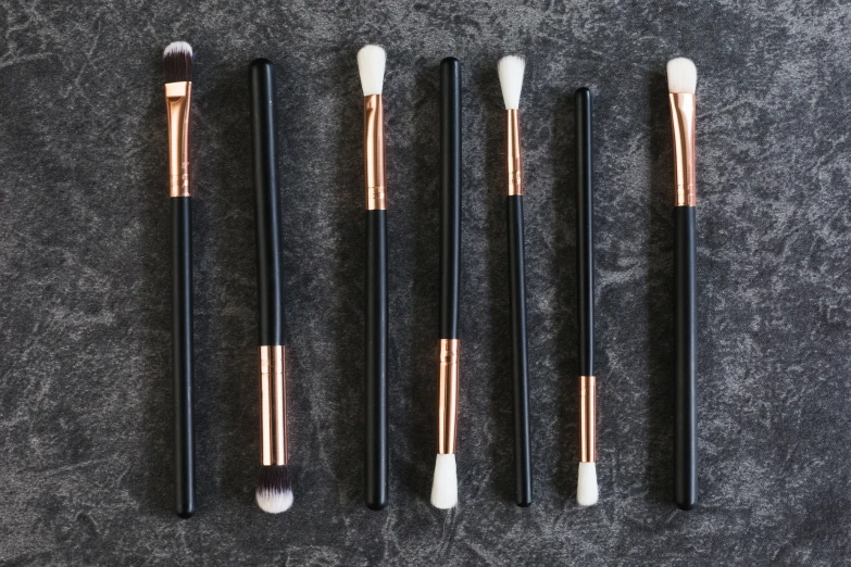 a black and gold brushes with white tips