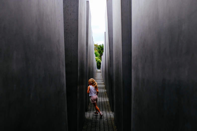 a little girl standing inside of an open archway