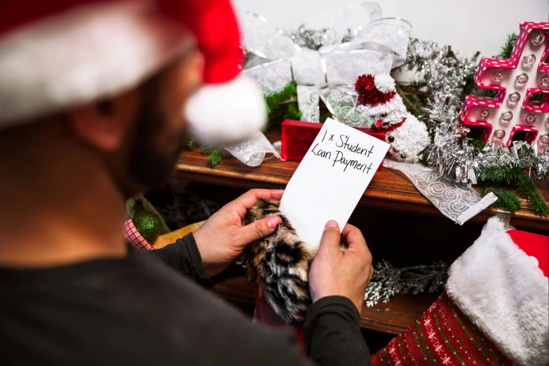 man holding greeting card for merry christmas from his dog