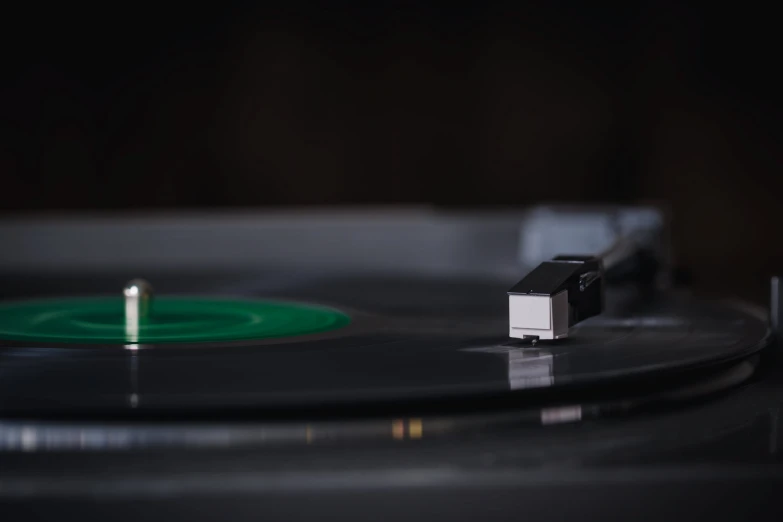 black and white record player with a small green disk