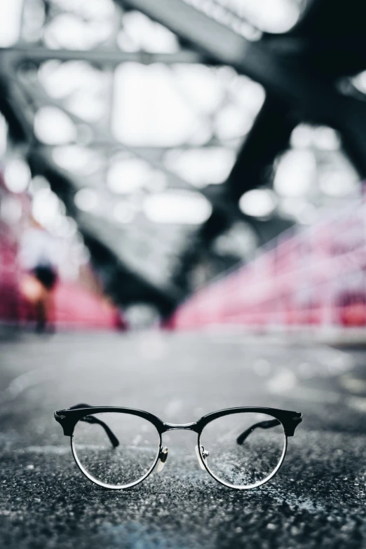 a pair of glasses sitting on top of a cement floor