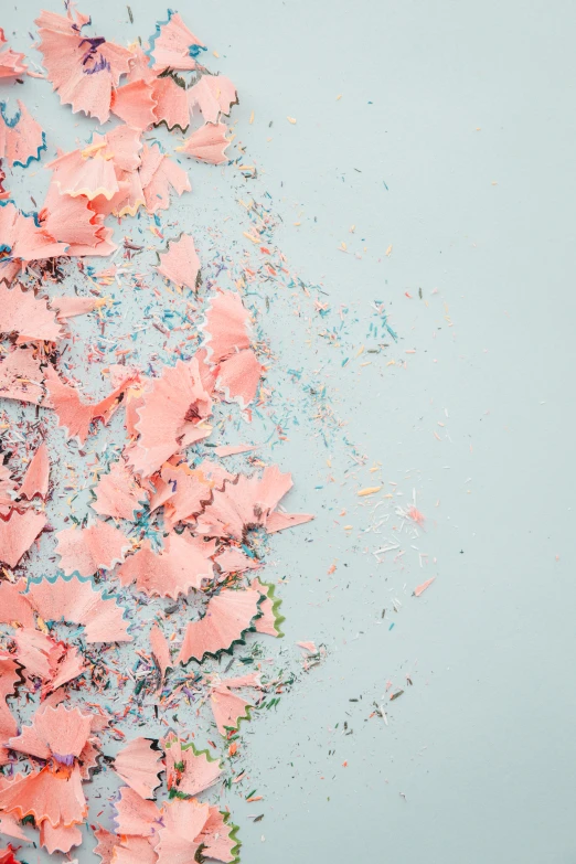 a lot of pink colored confetti on blue paper