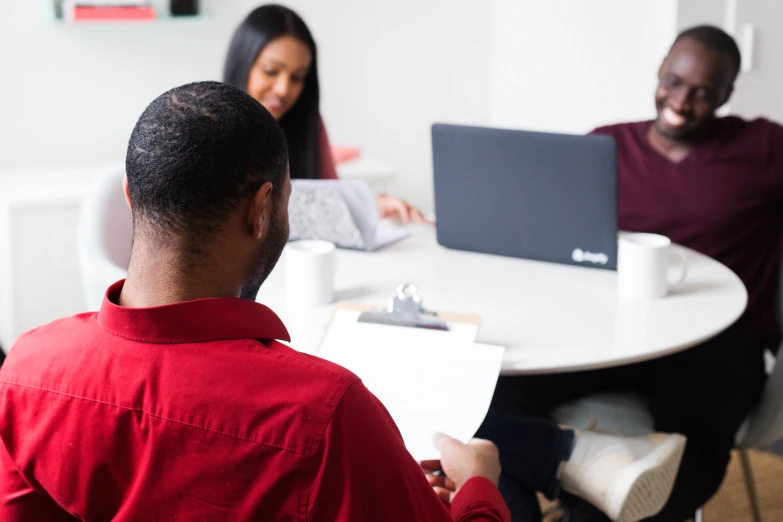 two people looking at a laptop and sitting at a table