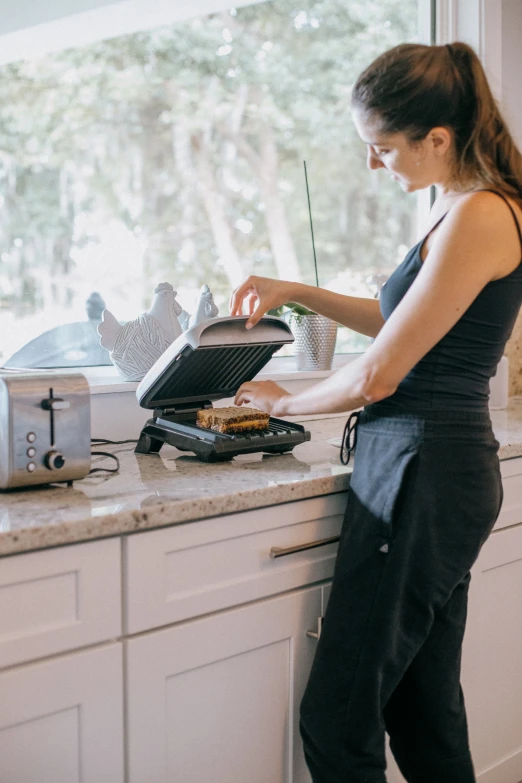 a woman standing in a kitchen preparing food on top of a counter