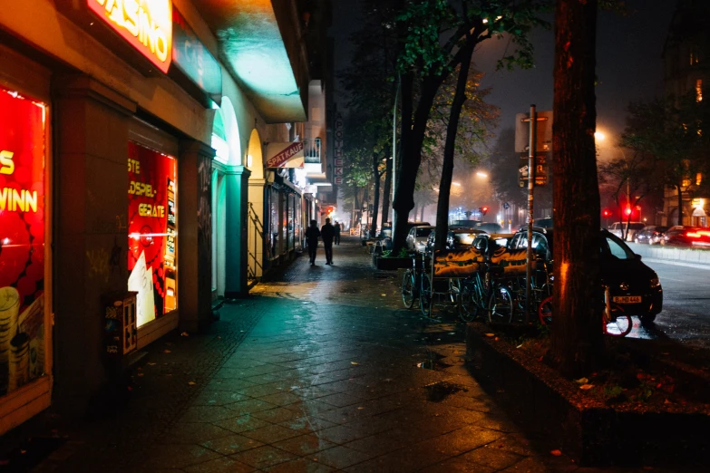 the sidewalk at night, where people are sitting