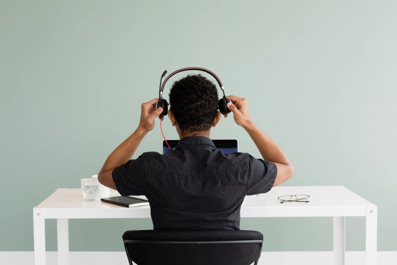 a man sitting at a table with headphones on his ears