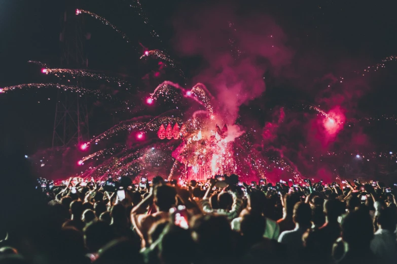 a huge crowd of people standing around with firework