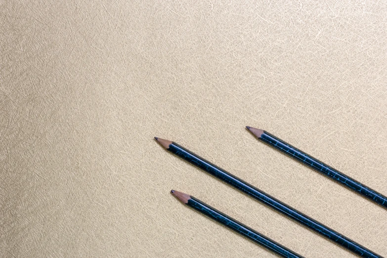 there are three blue pencils in front of an open book