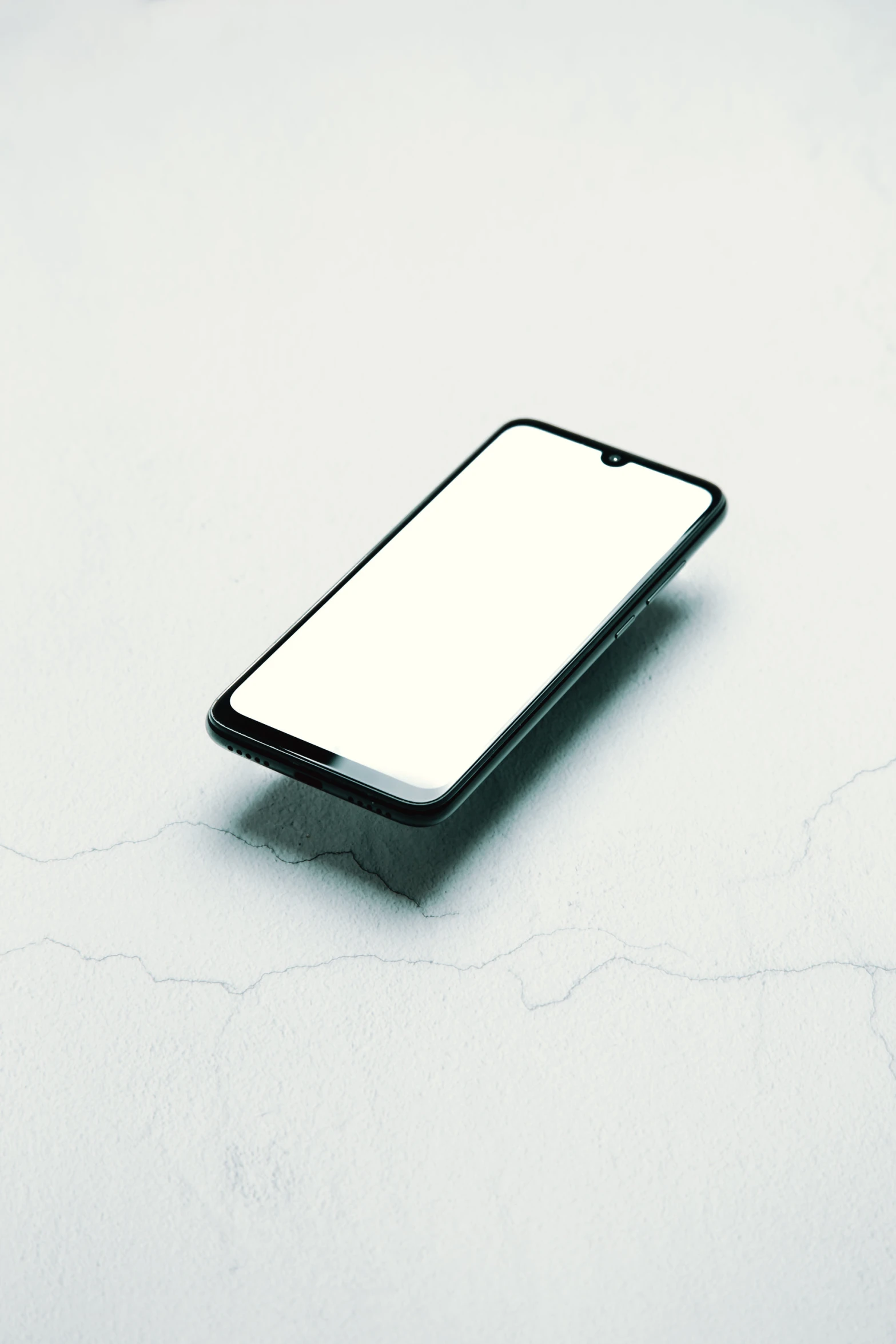 a white and black iphone sitting in front of a computer mouse