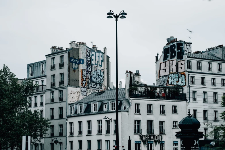 some buildings and a street lamp with graffiti on them