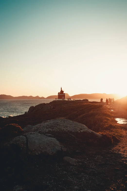 a lighthouse is seen at the top of a hill