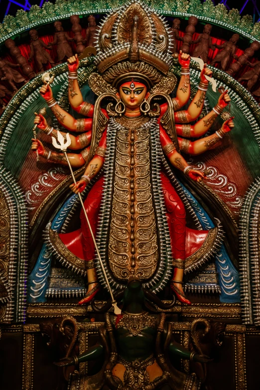 colorful sculpture in hindu temple of a woman with five arms and three feet