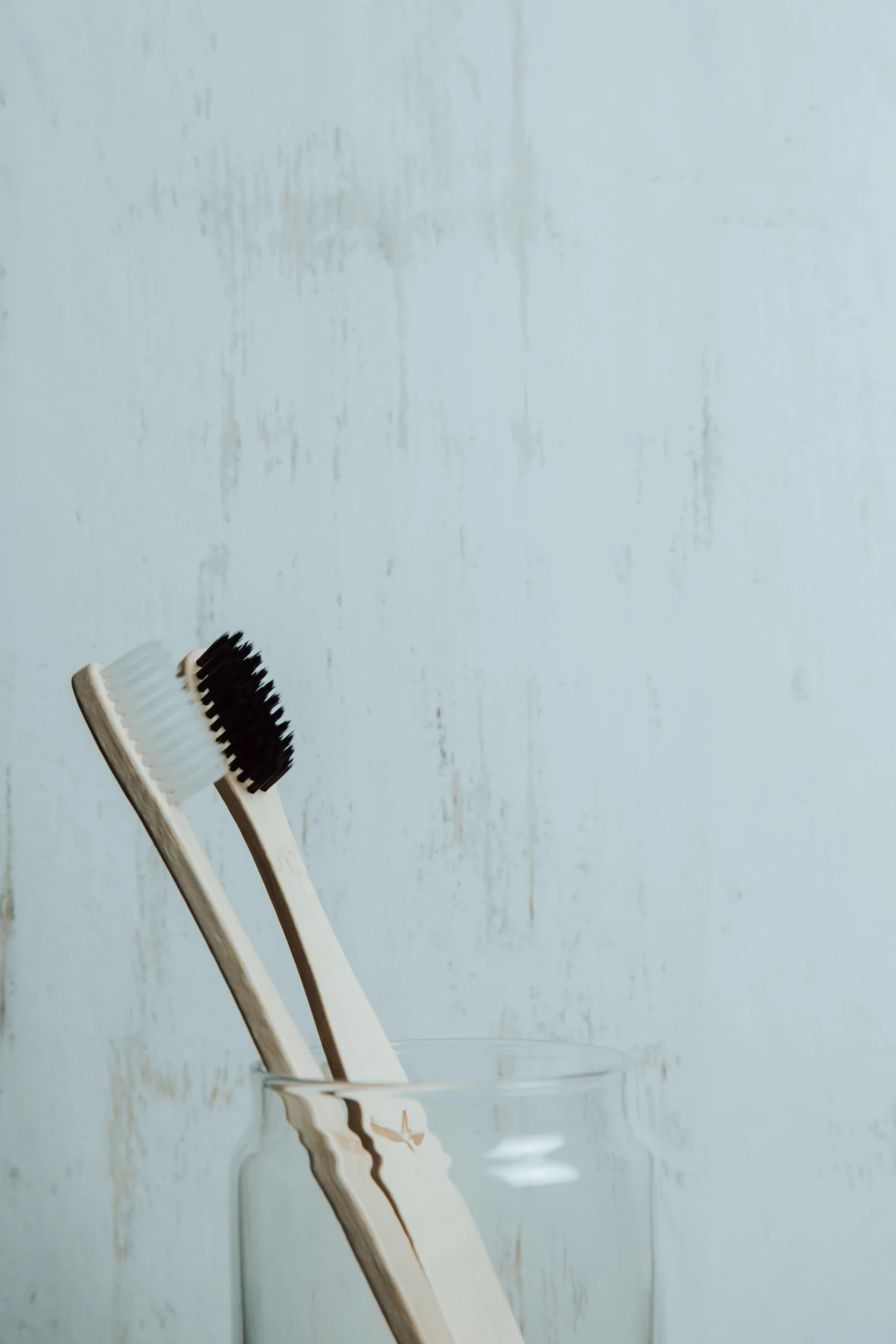 a glass with a plastic toothbrush inside on a wooden table