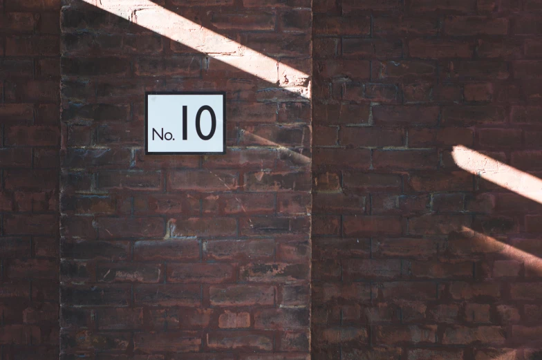 brick wall with two white signs on it