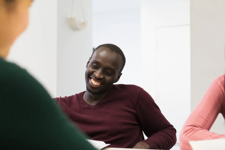 a man laughing at someone who is on his laptop