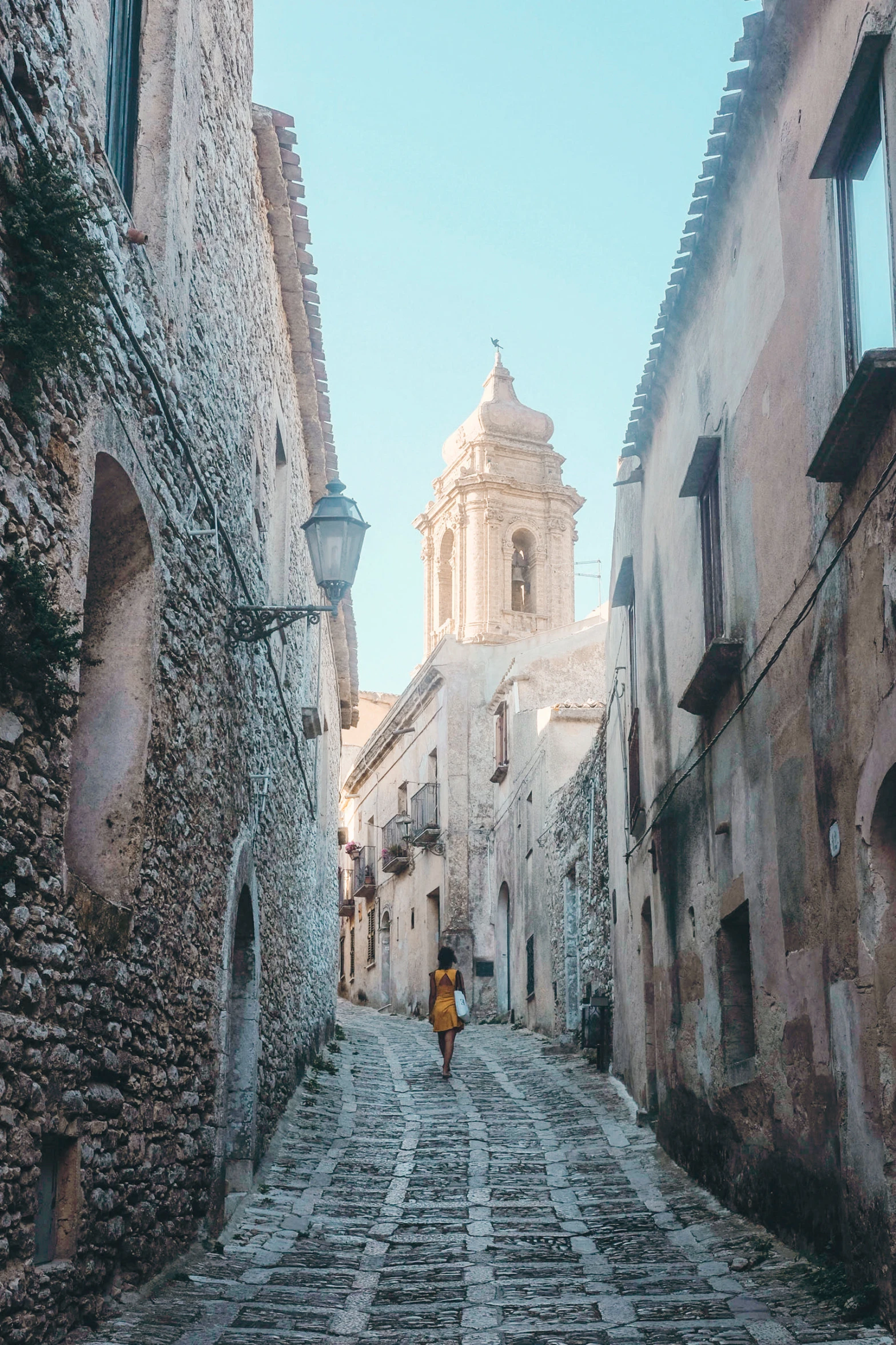 the lone person is in the middle of the cobblestone street