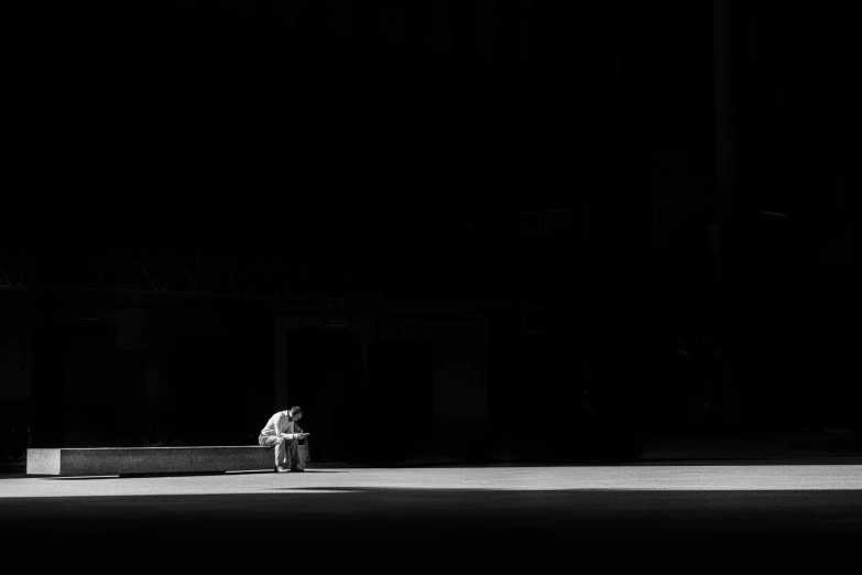 a man in a white jacket sitting on a bench