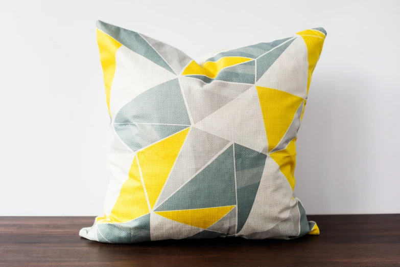 a decorative pillow made of fabric and painted in shades of blue, yellow, green, grey, orange