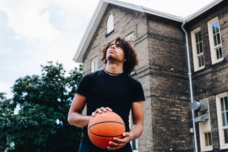 a man holding a basketball while wearing a black shirt