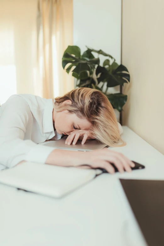 woman resting her head on her laptop