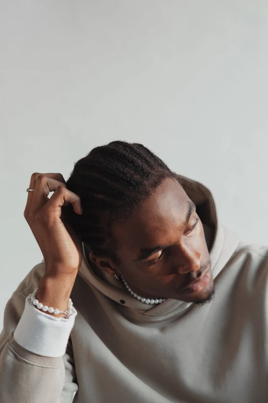 man with an unoned ponytail in a gray sweatshirt