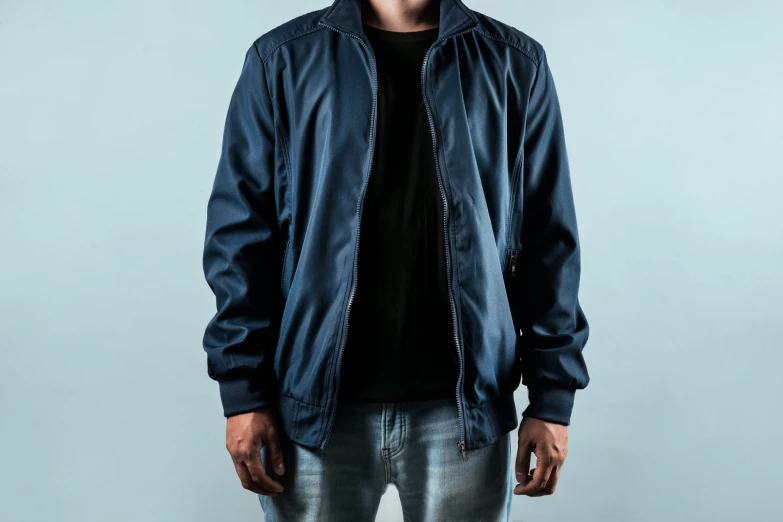 a man wearing jeans and a jacket poses for the camera