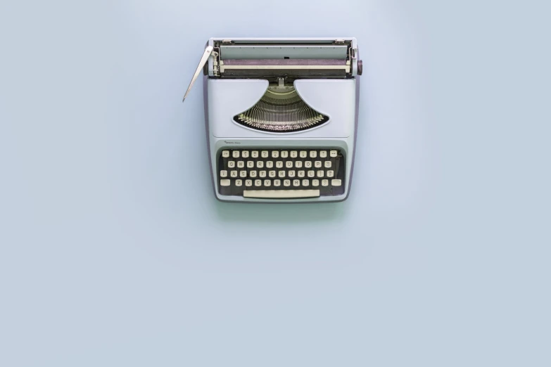 a typewriter on a light blue background