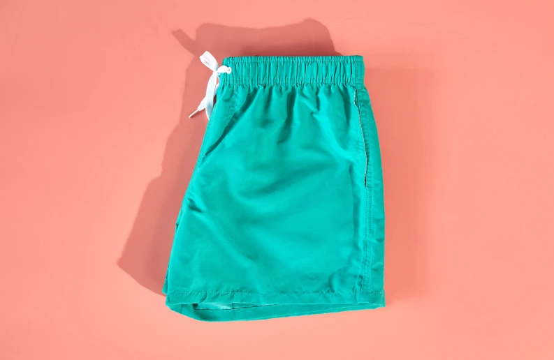 the turquoise shorts with white draws are on a pink background