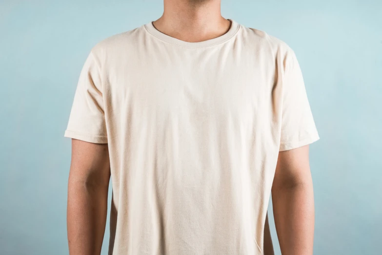 a man standing and looking back while wearing a t - shirt