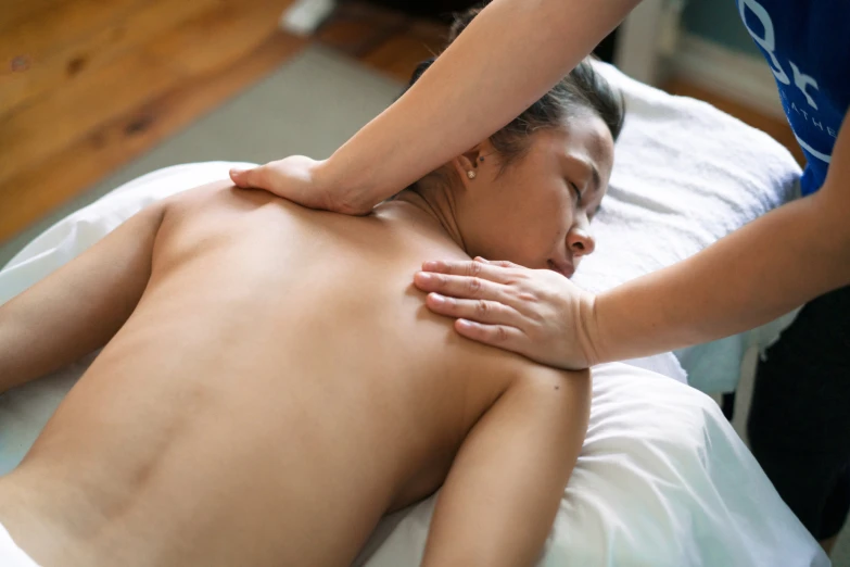 a person getting massage on the back of a bed