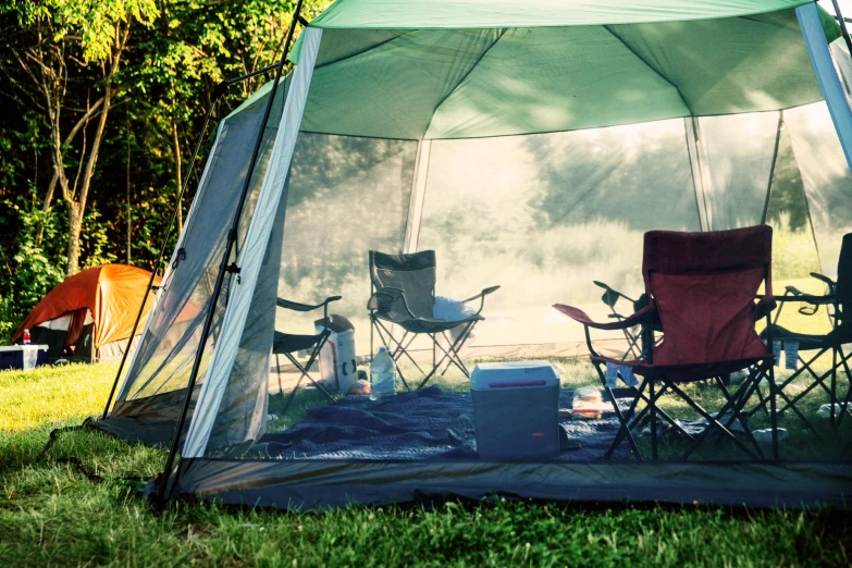 a tent with two chairs sitting inside of it