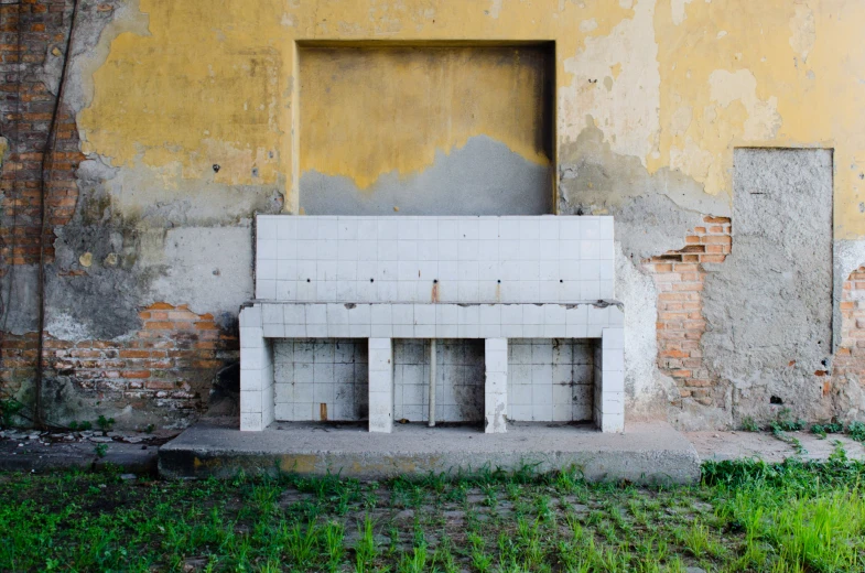 an empty bench against the wall and crumbling buildings