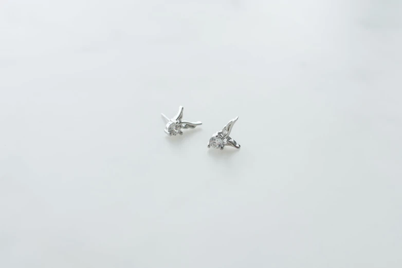 small earrings of different styles with one tiny diamond in the middle