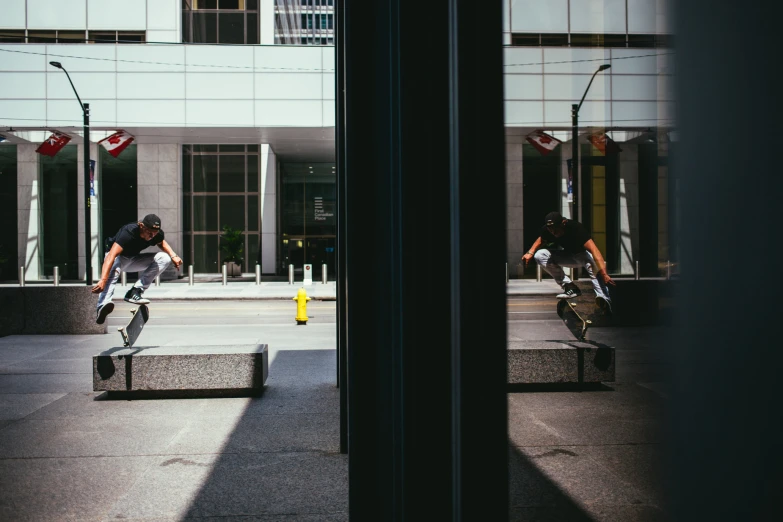 two skateboarders in motion performing stunts in front of a building