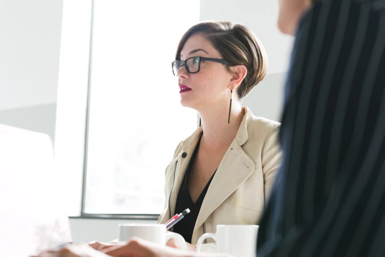 a man and woman talk at a table in a conference room