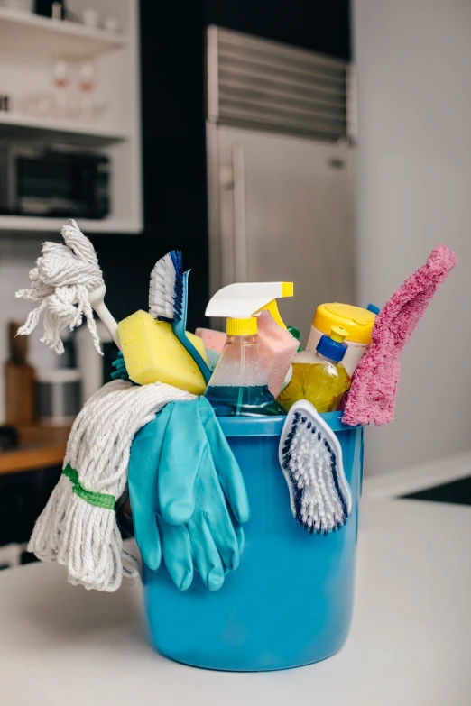 a bucket full of cleaning supplies on a counter