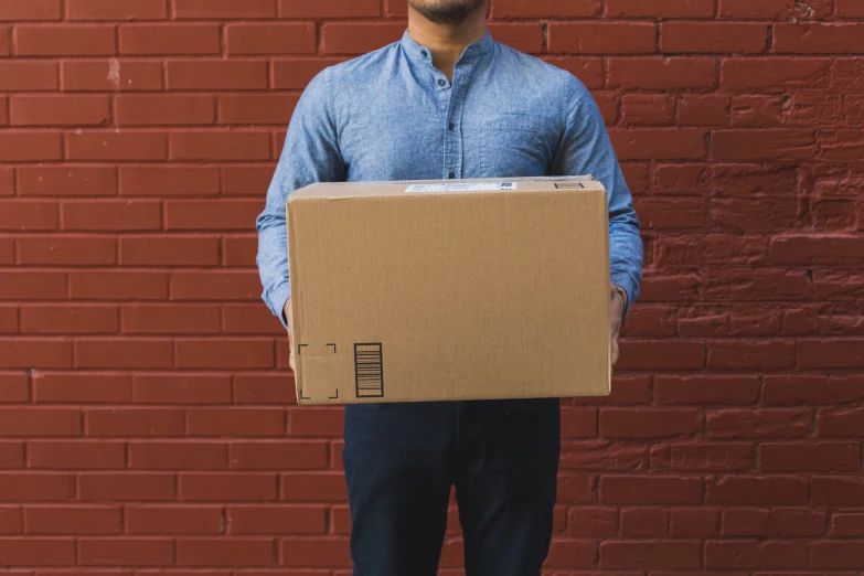 a man standing with a moving box on his back