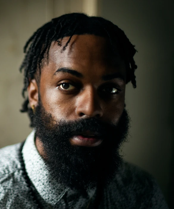 a man wearing a sweater looks serious as he looks straight ahead