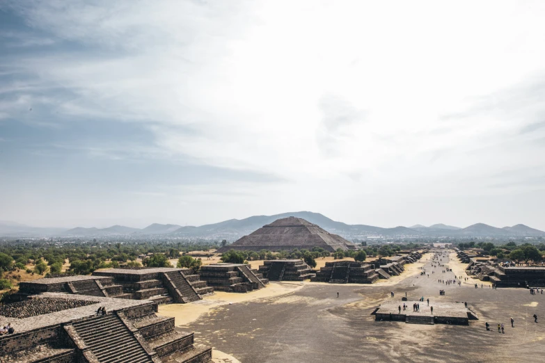 people walk around the ancient city near pyramids