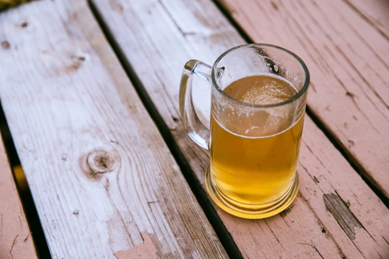 an mug full of light beer sits on a table