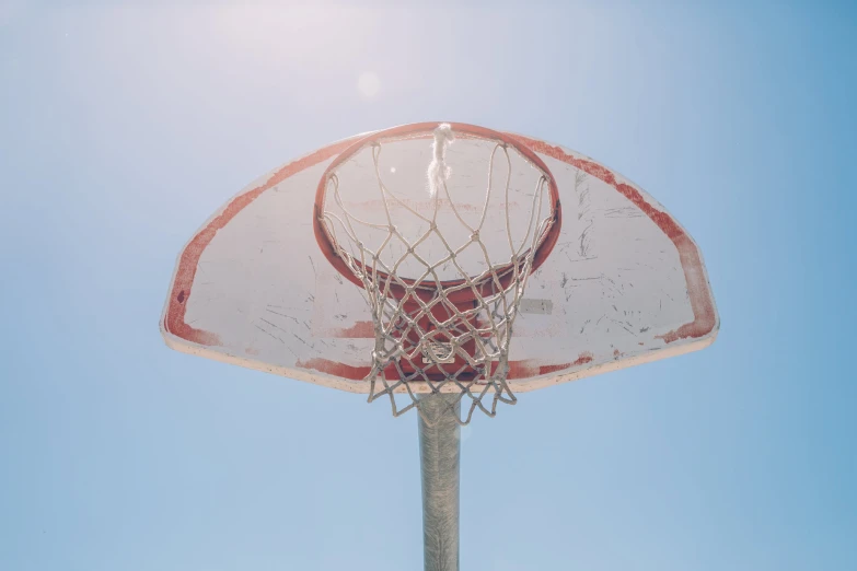 an old basketball net against a blue sky