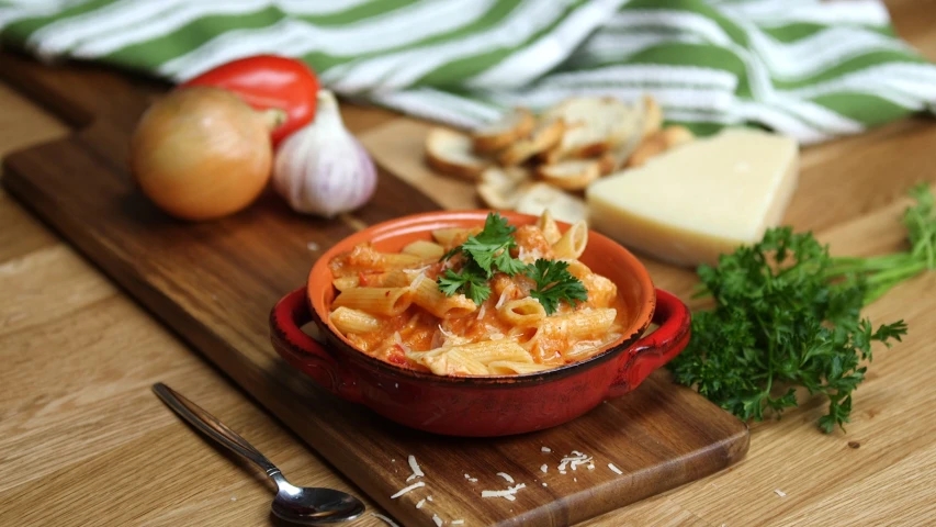 a red bowl full of pasta and other food