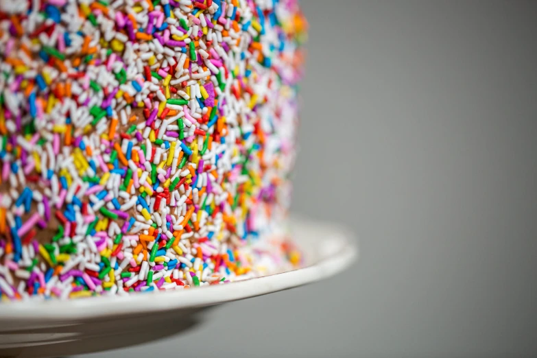 the cake is covered with sprinkles and multi - colored frosting