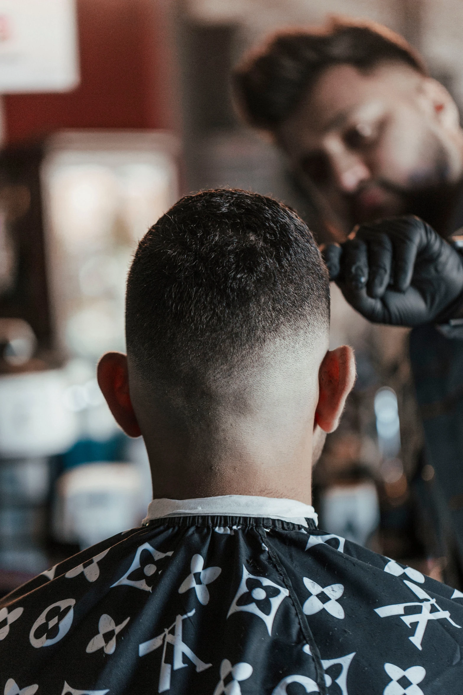 a young man  another mans hair at a barber shop