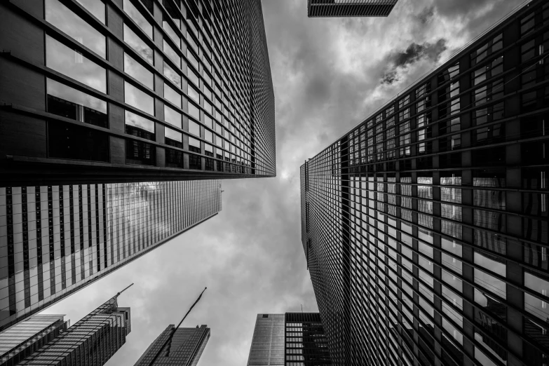 black and white pograph of tall buildings against a cloudy sky