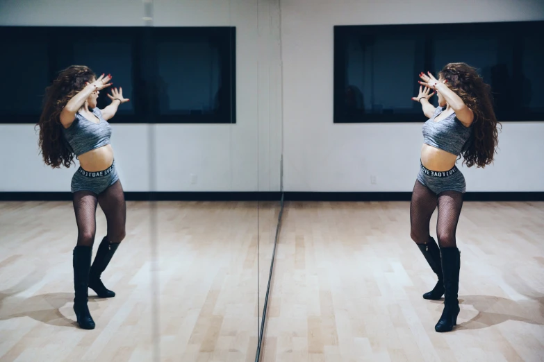 a woman is dancing in front of a mirror