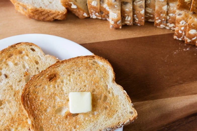 two pieces of bread on a white plate with cheese