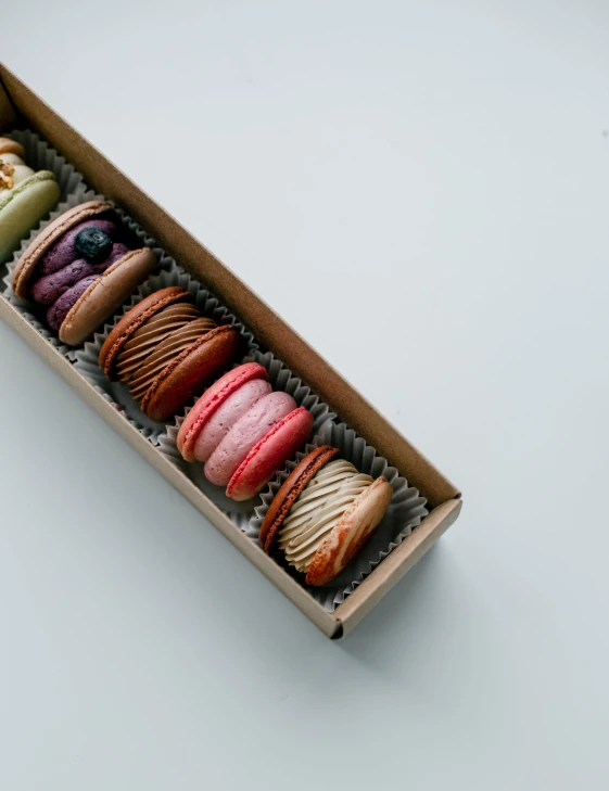 a box filled with different colored donuts