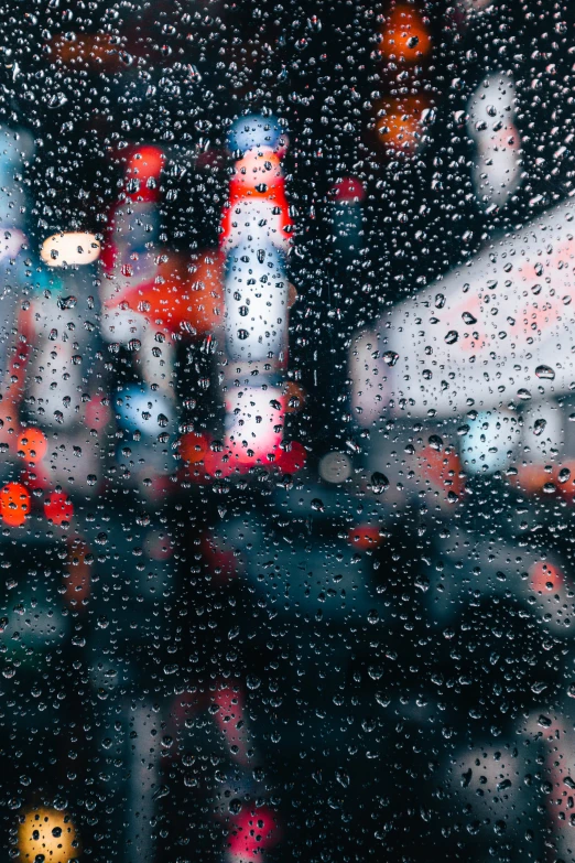 a person stands outside under an umbrella as rain begins to fall